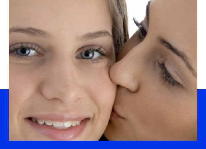 A woman kissing another woman 's cheek.